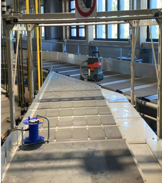 Close-up of specialized CleanBelt conveyor cleaning equipment with high-pressure vacuum bars for hygienic facility standards.